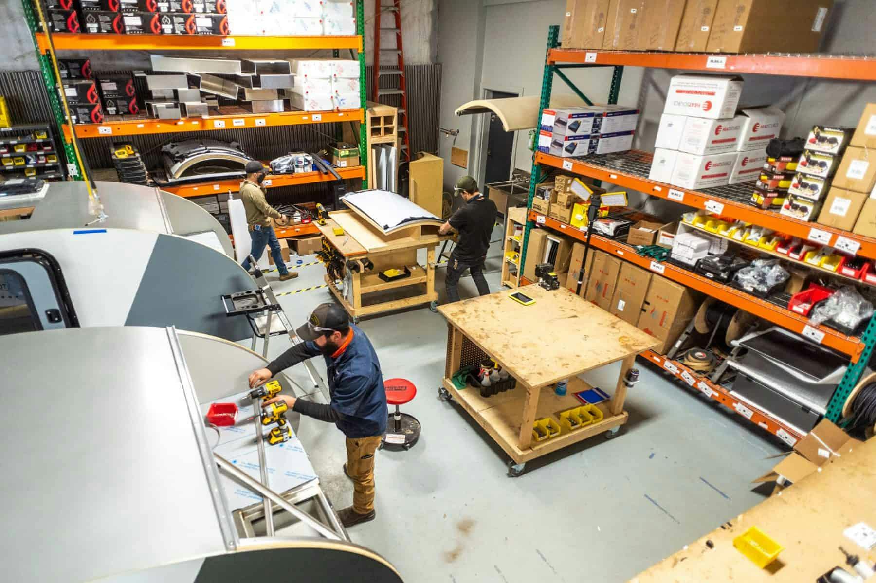 Craftpeople working a small manufacturing shop building offroad teardrop campers.