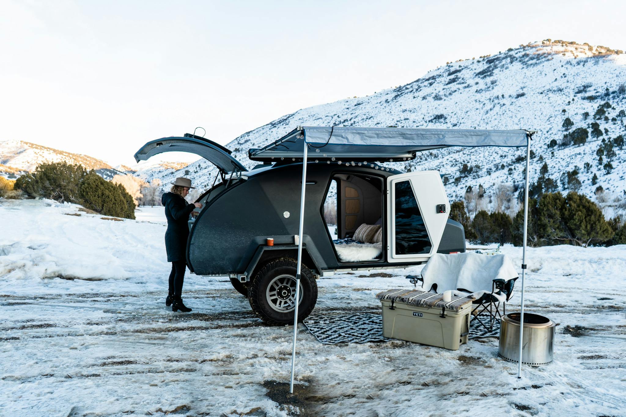 Winter camping in an adventure camper, cooking a camp meal.