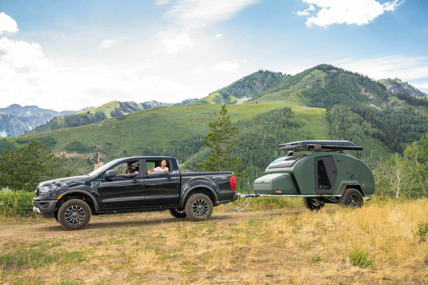 A family arriving to their campsite with their adventure camper in tow.