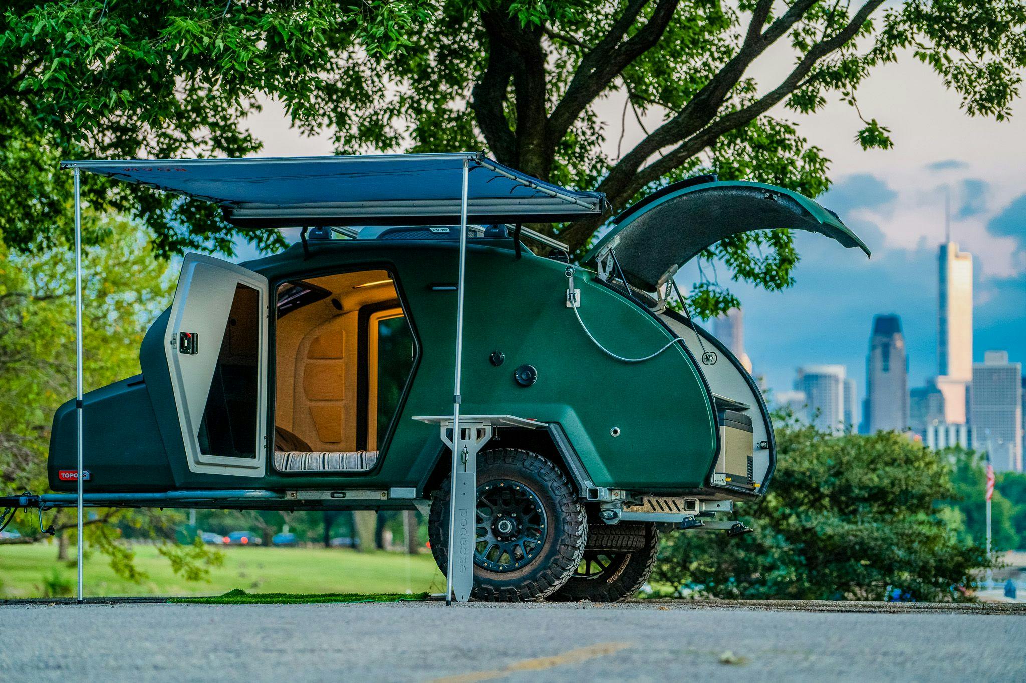 A TOPO2 trailer parked in a camping spot with the city of Chicago in the background.