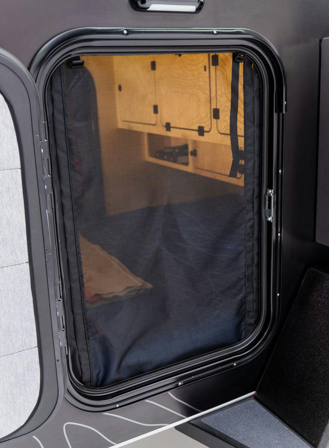 Bug screens installed on a teardrop camper in the doorway.