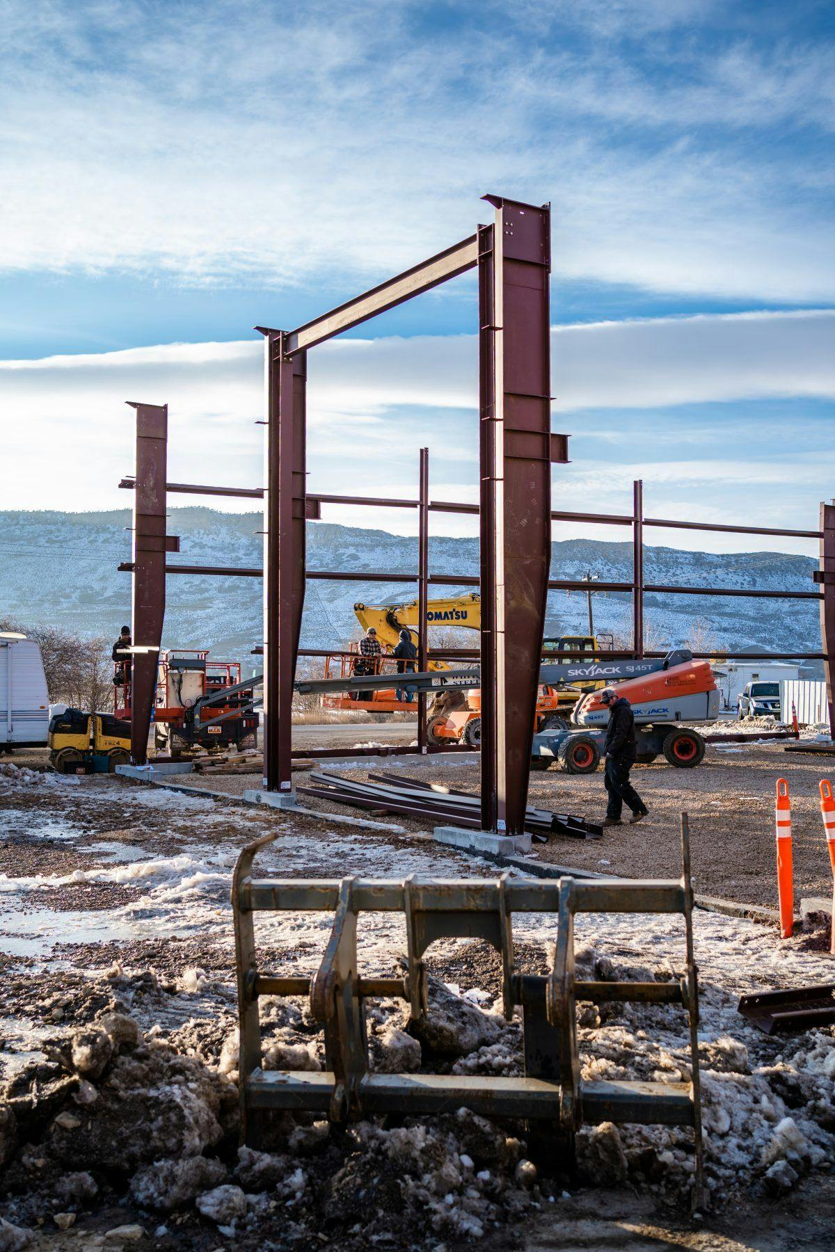 A blue sky winter day, with structural beams being set up to build a new manufacturing space.