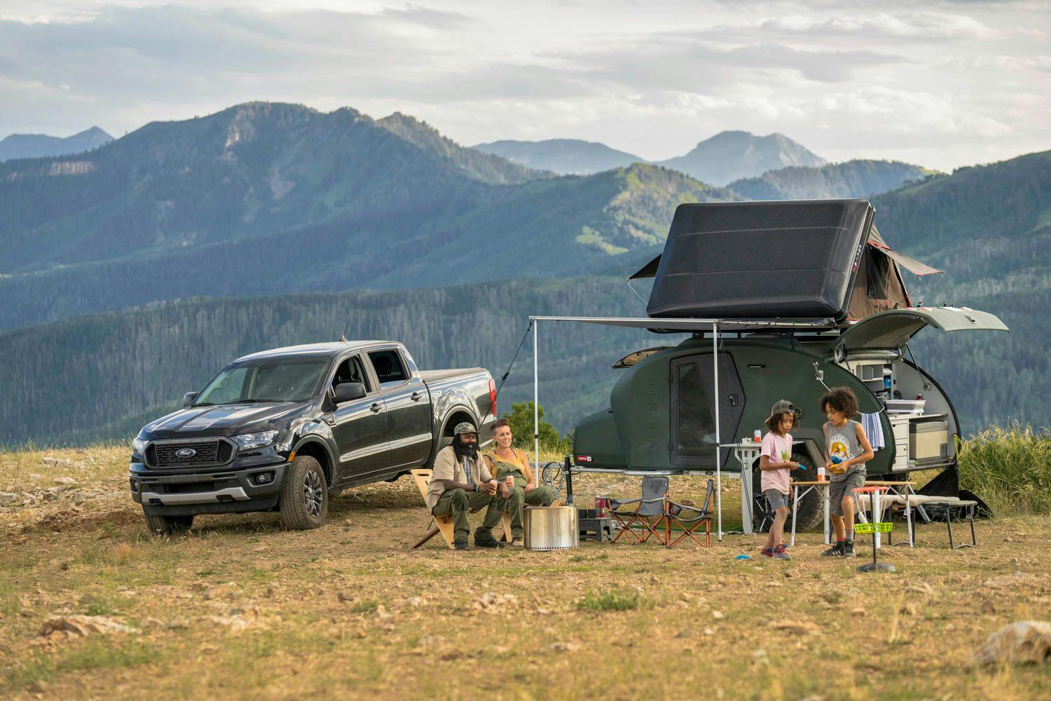 A family enjoying some campsite games in front of their teardrop camper.