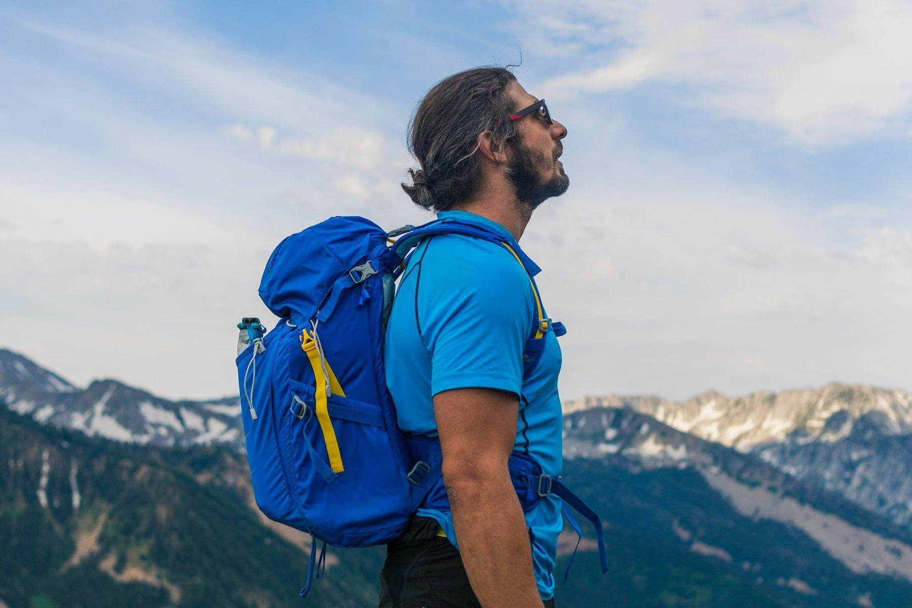 an image of a man reaching the top of a peak and taking in his surroundings.