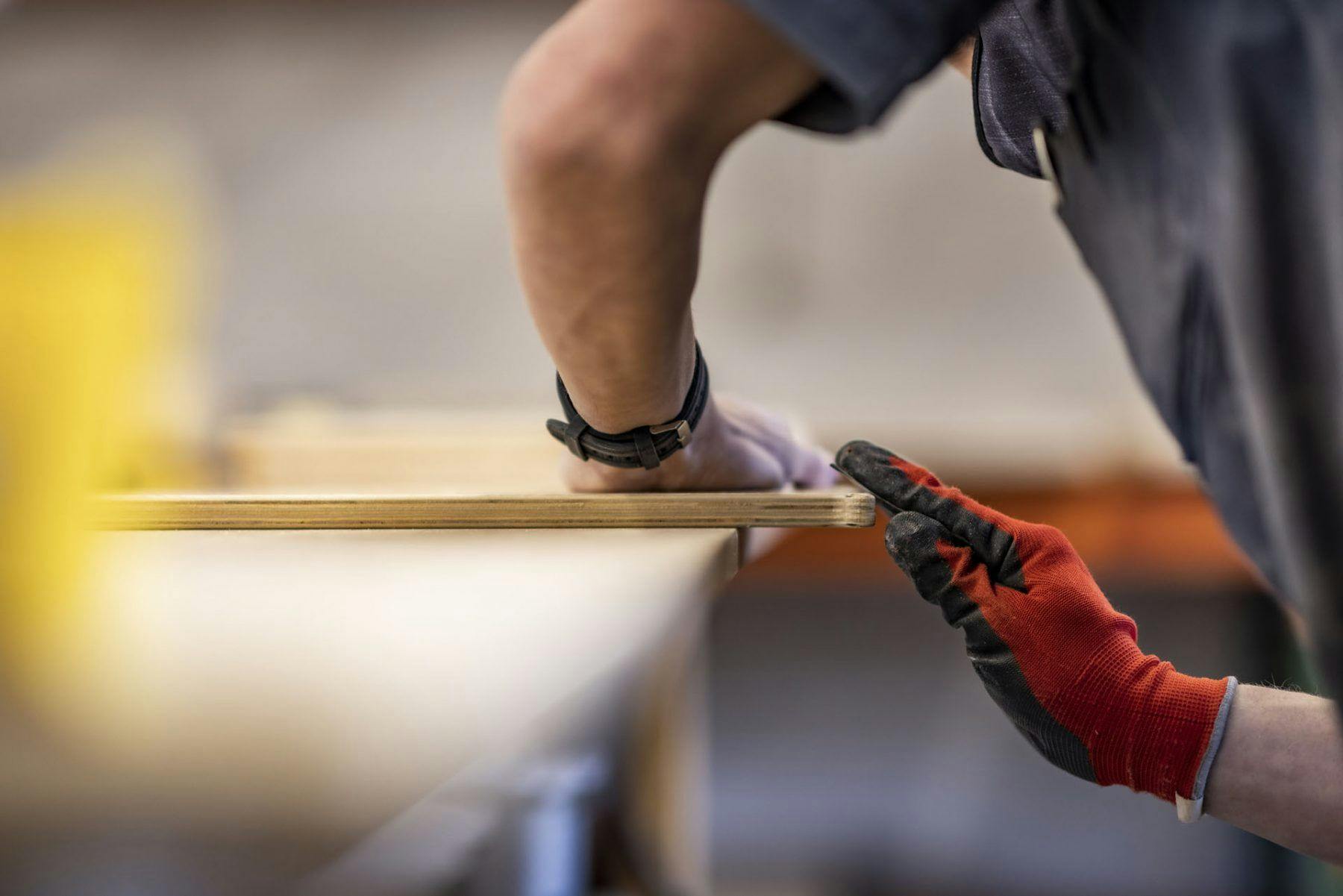 A craftsperson refining the materials used to create a teardrop camper.