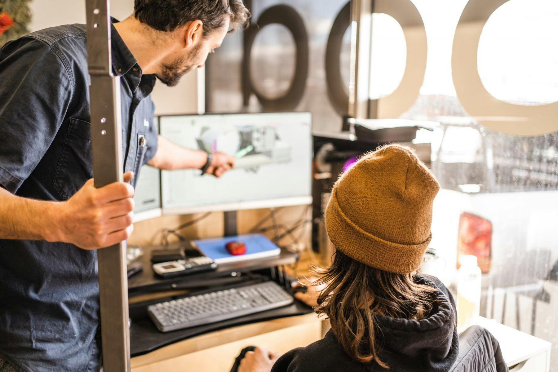 Two men working together to solve an issue on a computer.