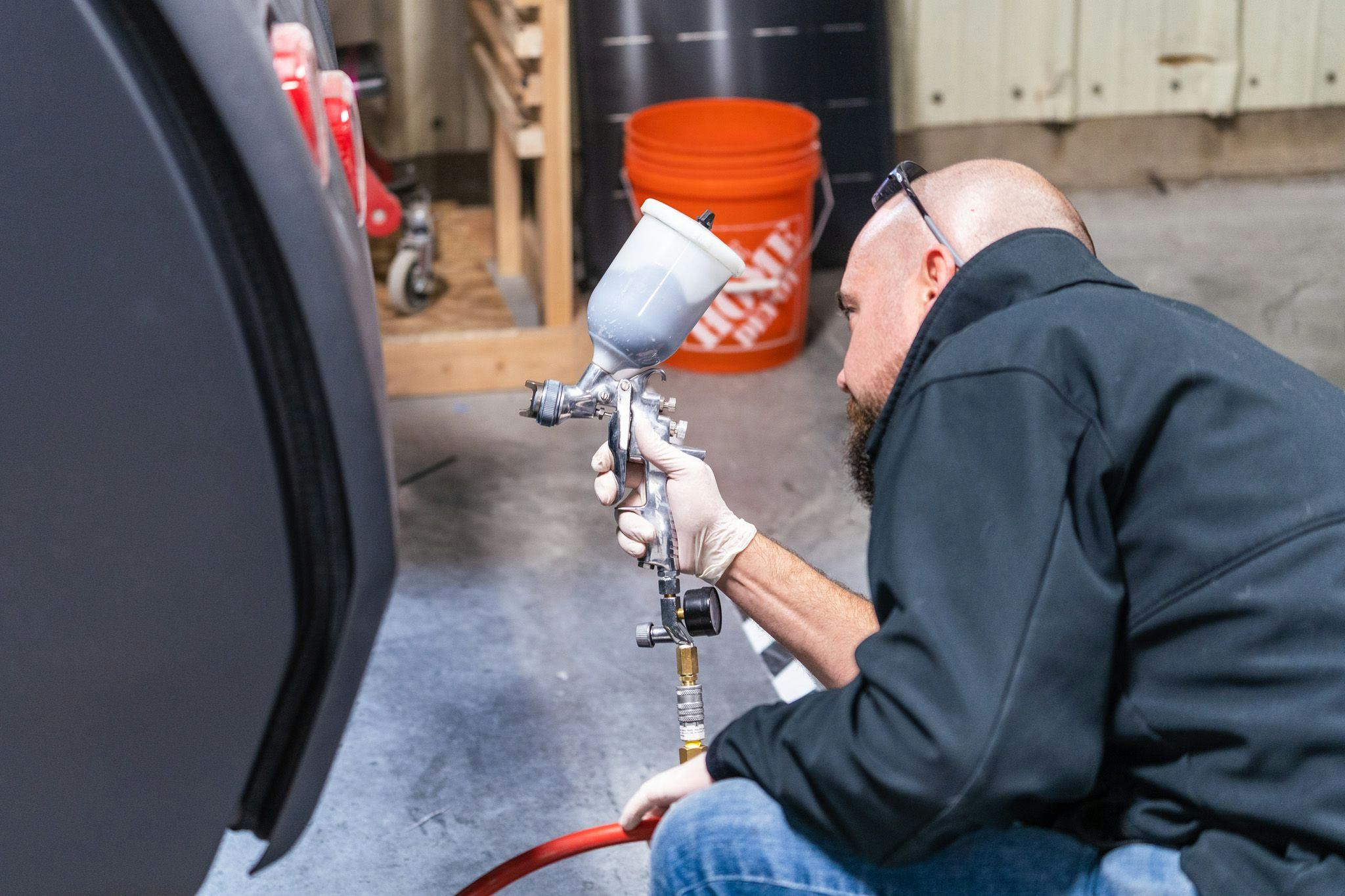 An employee of Escapod works to paint the body of a TOPO2.