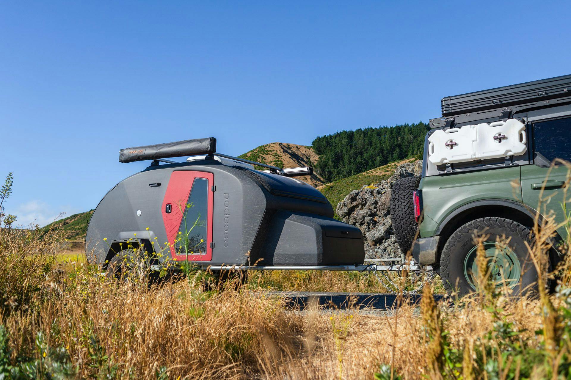 A storm gray TOPO2 being towed through California by a Bronco.