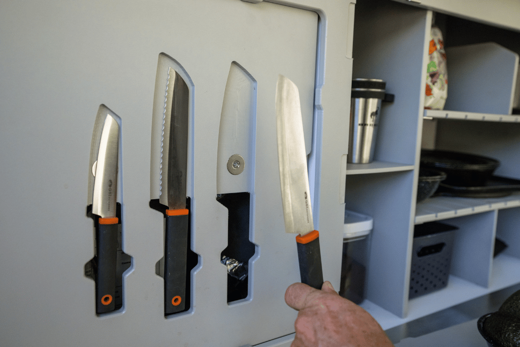 A person pulls a knife from it's magnetized recessed spot in the TOPO2, an offroad adventure trailer by Escapod Trailers.