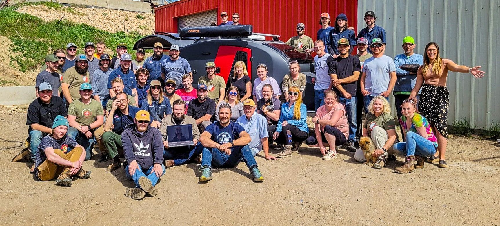 A team photo of Escapod's staff in summer 2022, outside the facility where they manufacture teardrop trailer builds.