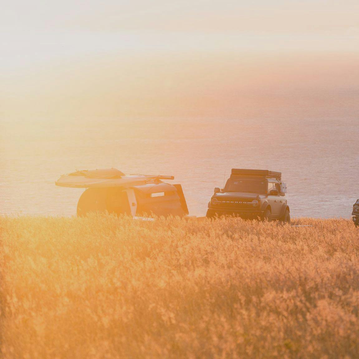 TOPO2 Voyager in a campsite overlooking the Pacific Ocean next to a Ford Bronco.