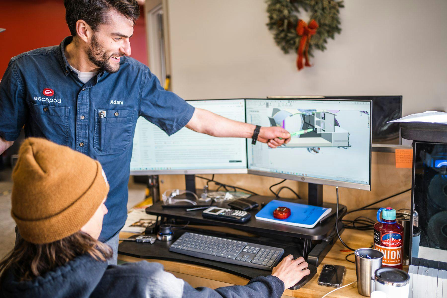 Two men working together to solve an issue on a computer.